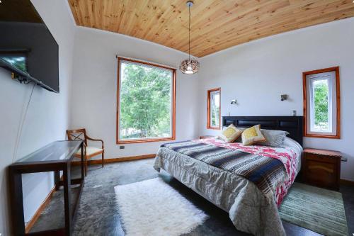 a bedroom with a bed and a flat screen tv at Cabañas del pillan in Pucón