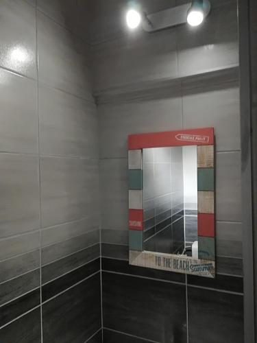 a bathroom with a mirror and a tiled wall at Apartment New Days in Sarajevo