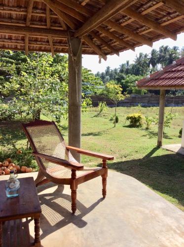 a wooden bench sitting under a pavilion on a patio at Sunshine Cafe in Tangalle