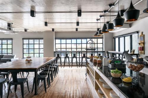 a large kitchen with a long table and chairs at Travelier Hostel in Bangkok