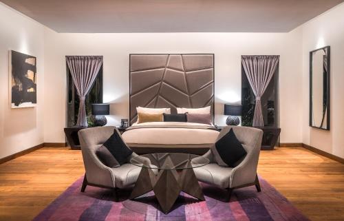 a bedroom with a bed and a table and chairs at The Edge Bali in Uluwatu