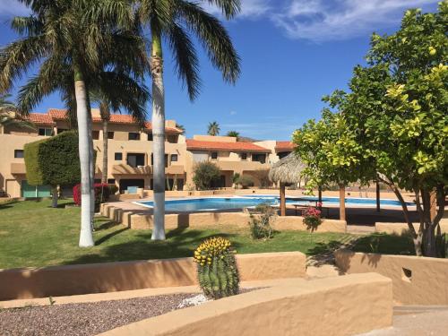 a resort with a swimming pool and palm trees at Villa en Marinaterra en seguida de Marina San Carlos in San Carlos