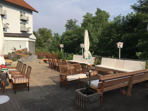 a patio with tables and chairs and a umbrella at TIPTOP Hotel am Hochrhein in Bad Säckingen