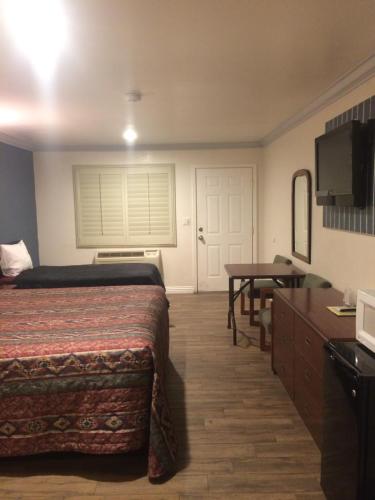 um quarto de hotel com uma cama e uma mesa em Royal Inn em Lomita