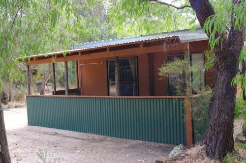 a green and brown house with a tree at Gracetown Caravan Park in Gracetown