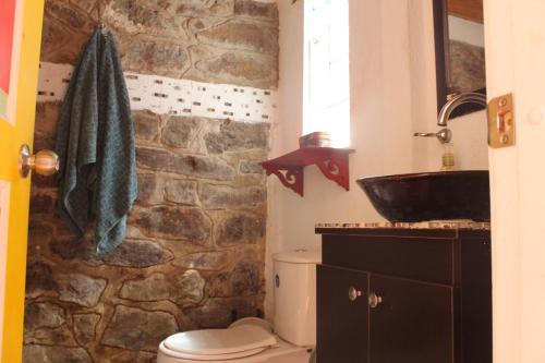 a stone bathroom with a sink and a toilet at Cucunuba por Siempre in El Salitre