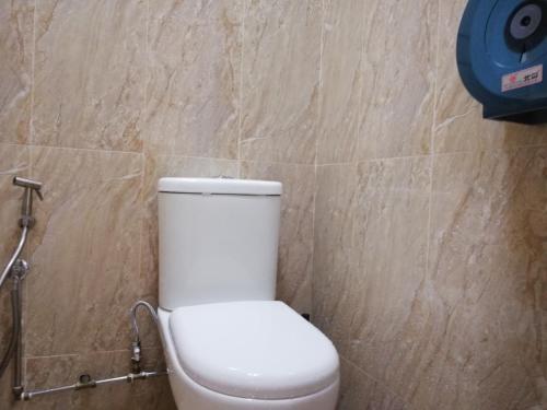 a white toilet in a bathroom with a stone wall at Spacepod@SG in Singapore
