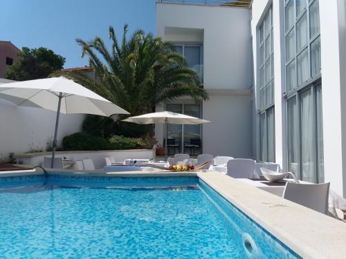 a swimming pool with chairs and umbrellas next to a building at Villa Andrea in Pula