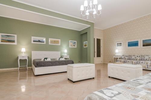 a bedroom with a bed and two white chairs at Vivi La Contea in Modica