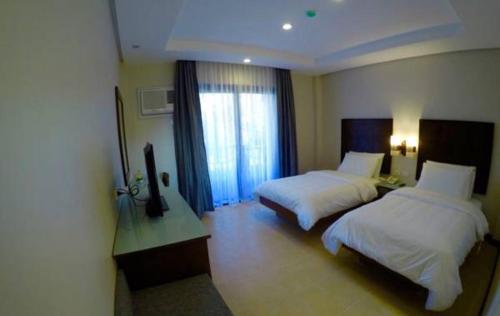 a hotel room with two beds and a window at MO2 Lagoon Coron in Coron