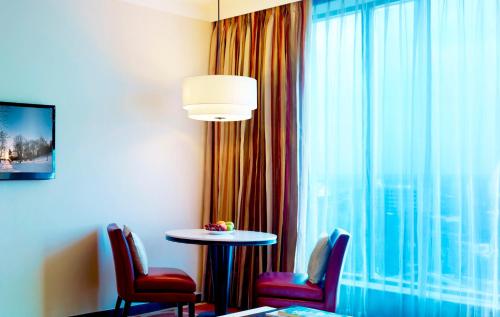 a room with a table and chairs and a window at Vivanta Coimbatore in Coimbatore