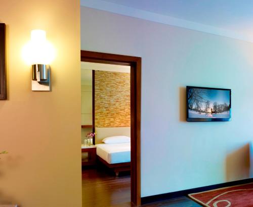 a room with a bedroom with a bed and a mirror at Vivanta Coimbatore in Coimbatore