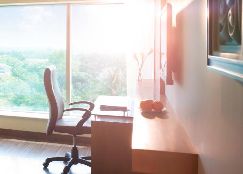 an office with a desk and a chair and a window at Vivanta Coimbatore in Coimbatore