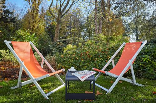 two chairs and a table in the grass at Mercure Paris Roissy CDG in Roissy-en-France