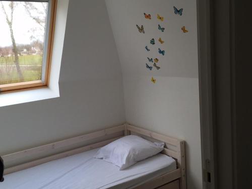 a bedroom with a bed with butterflies on the wall at Casa Topsea in De Panne