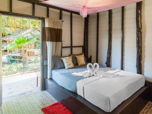 a bedroom with a bed with a bow on it at Leaf House Bungalows in Ko Lanta