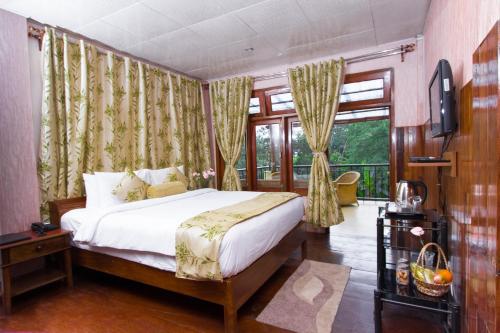 ein Schlafzimmer mit einem Bett und einem großen Fenster in der Unterkunft Niraamaya Retreats Aradura Kohima in Kohīma