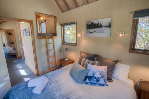 a bedroom with a bed with pillows on it at Sharpys Chalet in Dinner Plain