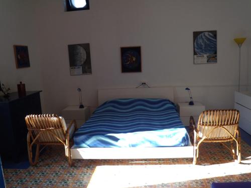 sypialnia z łóżkiem i 2 krzesłami w obiekcie Casa Ada w mieście Stromboli