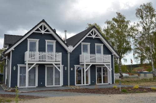 a blue house with white trim at Kojenhus Gager - F605 in Gager