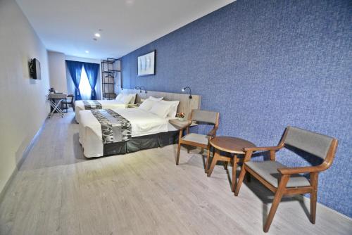 1 dormitorio con 1 cama, mesa y sillas en Diamond Inn en Kota Kinabalu