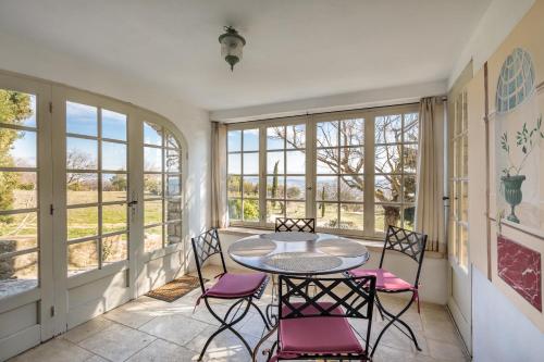 une pièce avec une table, des chaises et des fenêtres dans l'établissement La Maison des Roches, à Gordes