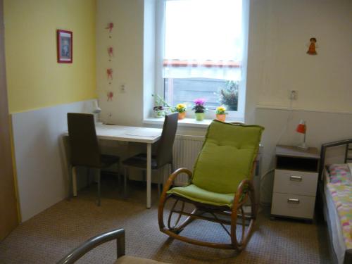a small room with a table and chairs and a window at Apartments - Penzion Lena in Hradec Králové