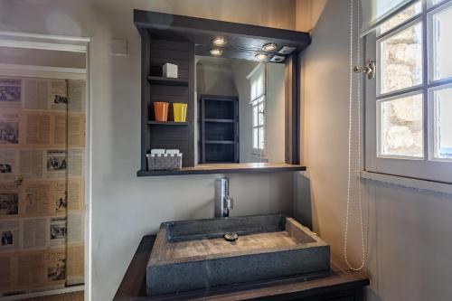 a bathroom with a stone sink and a mirror at La Maison des Roches in Gordes