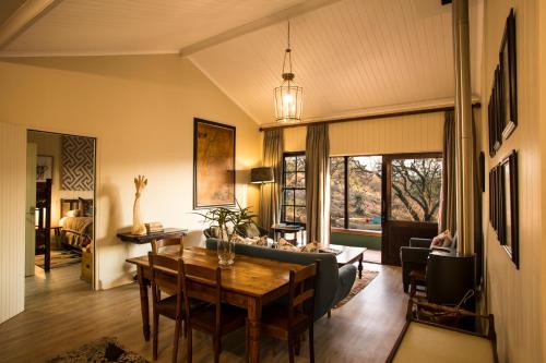 a living room with a table and a couch at Three Tree Hill Lodge in Bergville