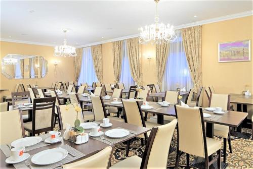 einen Konferenzraum mit Tischen, Stühlen und Kronleuchtern in der Unterkunft Rixwell Gertrude Hotel in Riga