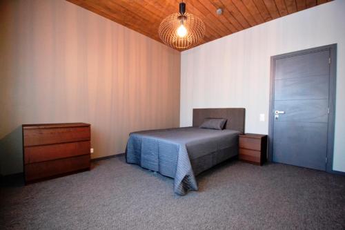 a bedroom with a bed and a dresser and a door at Prieka pietura (on Šveices street) in Sigulda