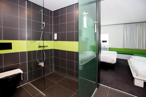 y baño con ducha y lavamanos. en Tulip Inn Eindhoven Airport, en Eindhoven