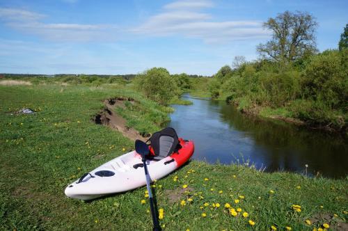 a kayak sitting on the side of a river at Jaunkrastmaļi in Kandava