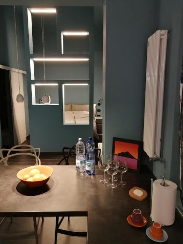 einen Esstisch mit einer Schale Obst und Weingläsern in der Unterkunft Casa Nostra 14 in Bologna
