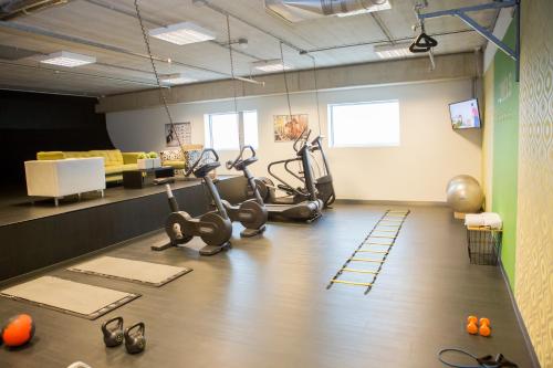 a gym with treadmills and exercise bikes in a room at Tulip Inn Eindhoven Airport in Eindhoven