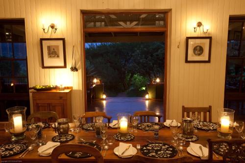 a wooden table with candles and plates on it at Three Tree Hill Lodge in Bergville