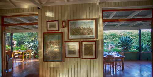 a group of pictures on a wall in a dining room at Three Tree Hill Lodge in Bergville