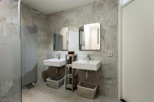a bathroom with two sinks and two mirrors at Appartement in Zeeland - Kabbelaarsbank 405 - Port Marina Zélande - Ouddorp - not for companies in Ouddorp