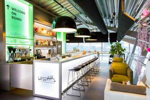 a bar in a restaurant with a counter and stools at Tulip Inn Eindhoven Airport in Eindhoven
