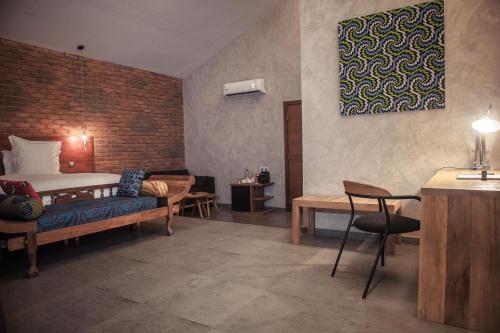 a bedroom with a bed and a table and chairs at Le Patio in Lomé