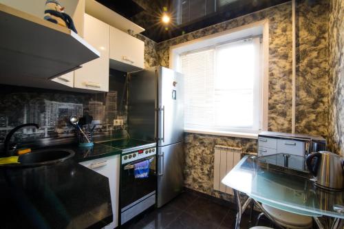 a kitchen with a refrigerator and a counter top at Apartments on Kirova 76 in Novokuznetsk