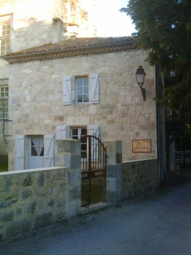 FourcèsにあるGîte, appartement "Le One"の門と通りがある古い石造りの建物
