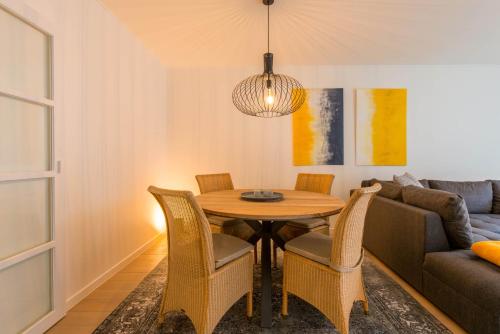 een eetkamer met een tafel en stoelen en een bank bij Yellow in Knokke-Heist