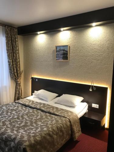 
a hotel room with a bed and two lamps at Podvorye Hotel in Tula
