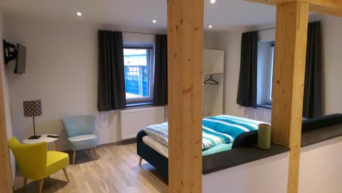 - une chambre avec des lits superposés et une chaise jaune dans l'établissement Beim Hooch "Traud", à Brücktal