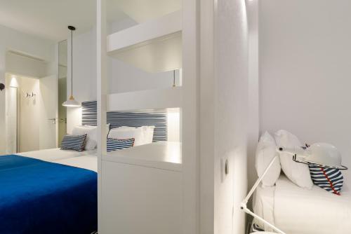 a white room with two beds and a mirror at Hotel 34B - Astotel in Paris