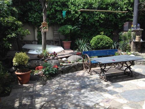 a garden with a bench and a table and plants at Craftsman's Home in Tbilisi City