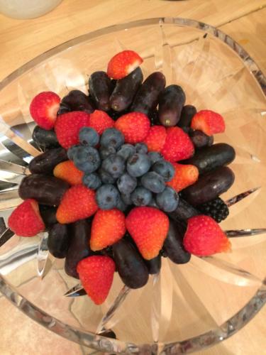 a glass bowl filled with strawberries and berries on a table at Acorn Guest House in Hull in Hull