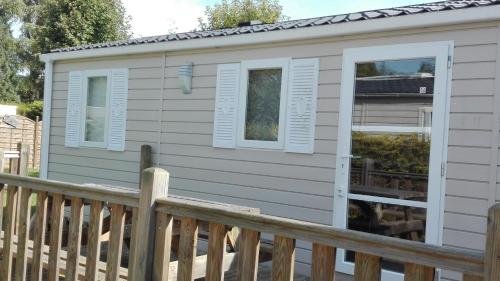 a tiny house with a porch at Camping Loisirs Des Groux in Mousseaux-sur-Seine