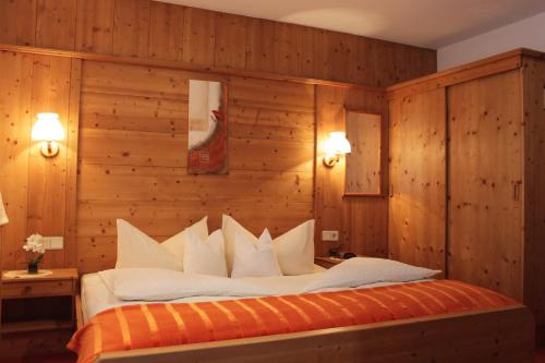 1 dormitorio con 1 cama grande y paredes de madera en Birkenheim Widmann en Längenfeld